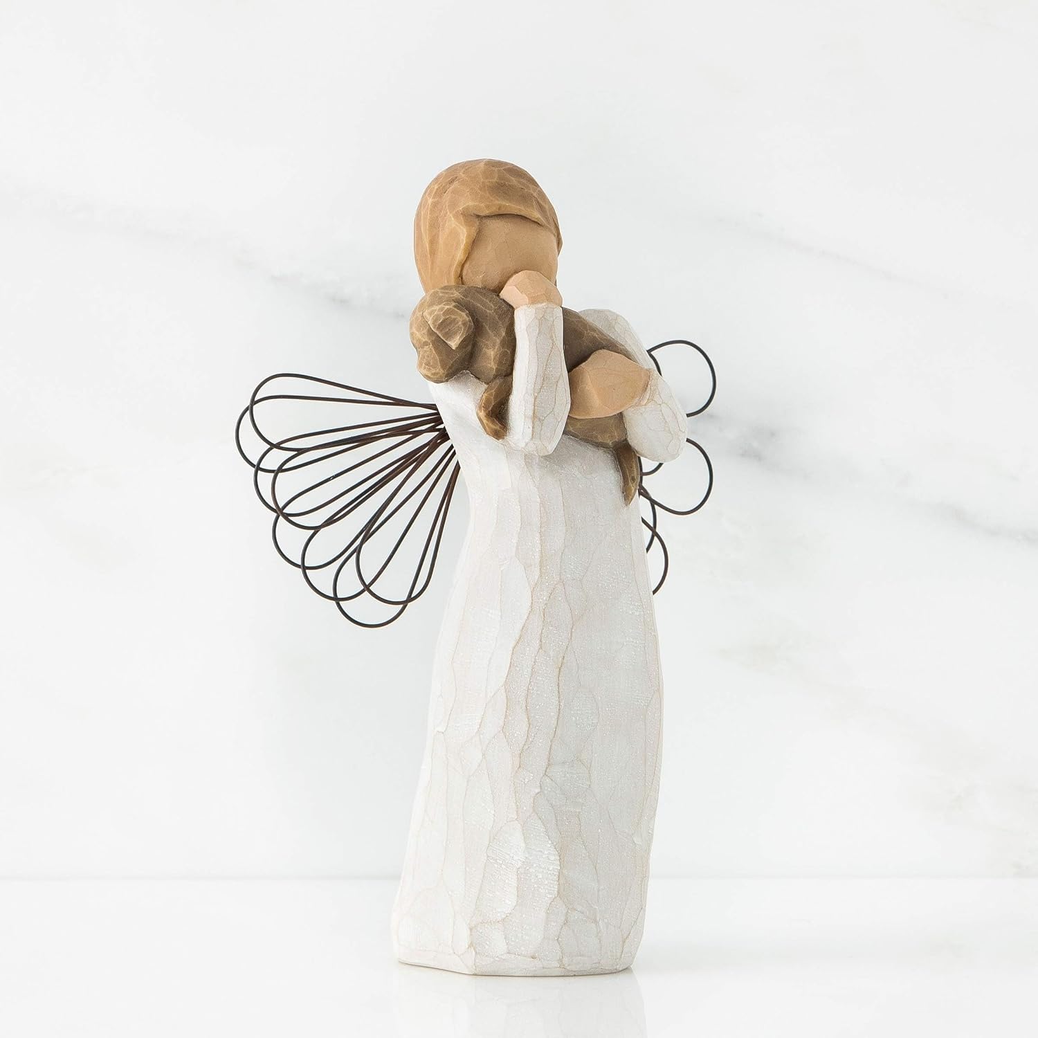 Hand-carved angel figurine holding a dog