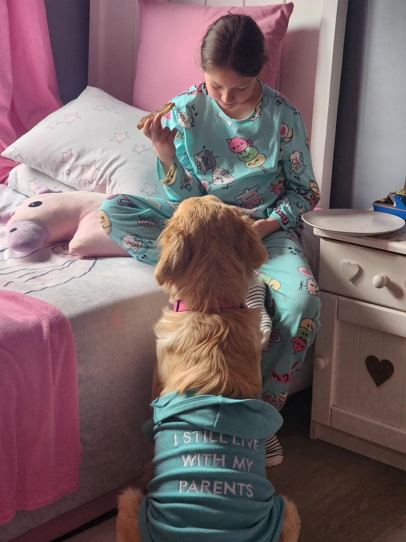 Lana in her I Still Live With My Parents hoodie begging while a little girl eats toast