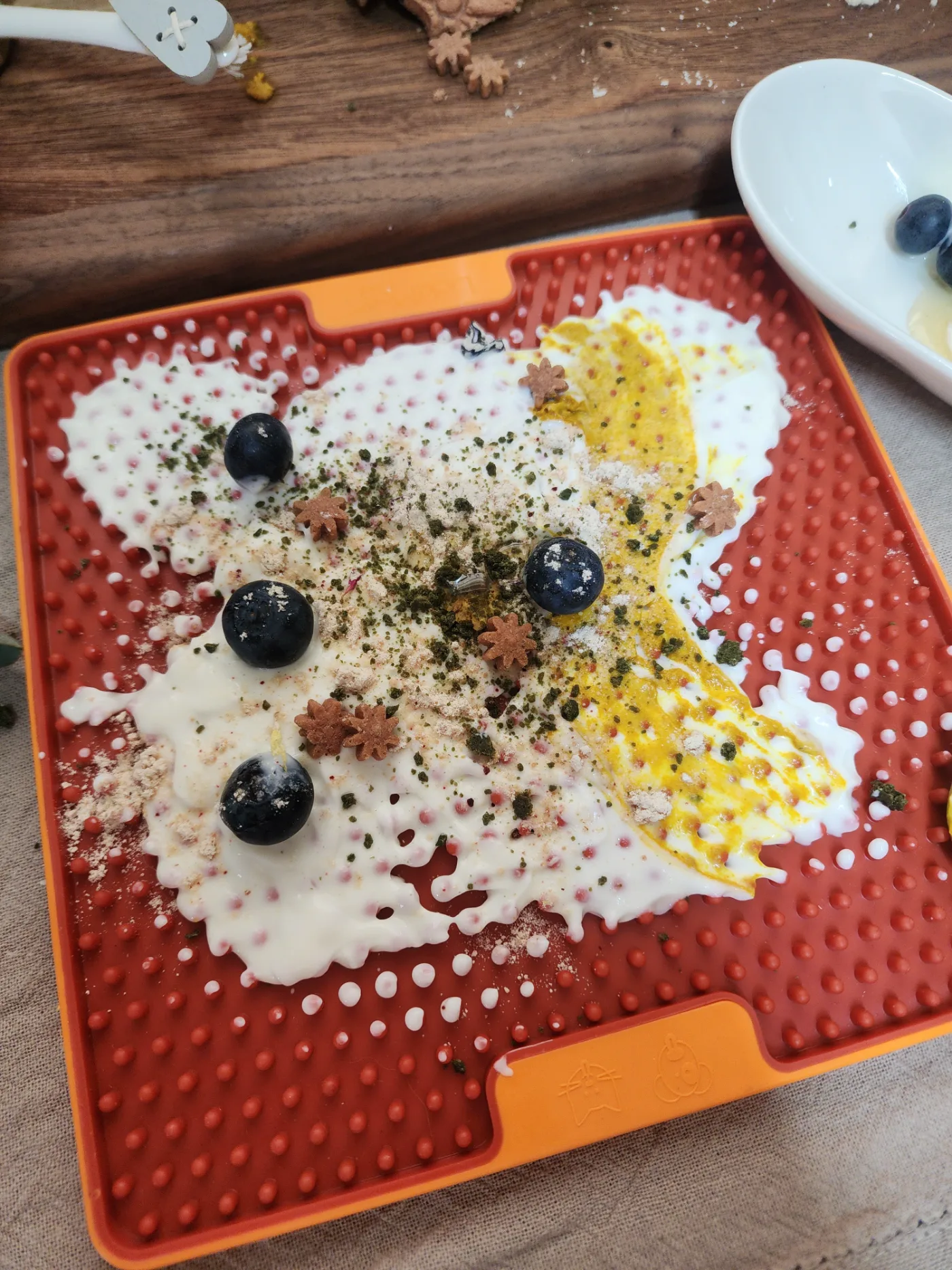 Lick mat loaded with yogurt, blueberries and pumpkin, three combinations