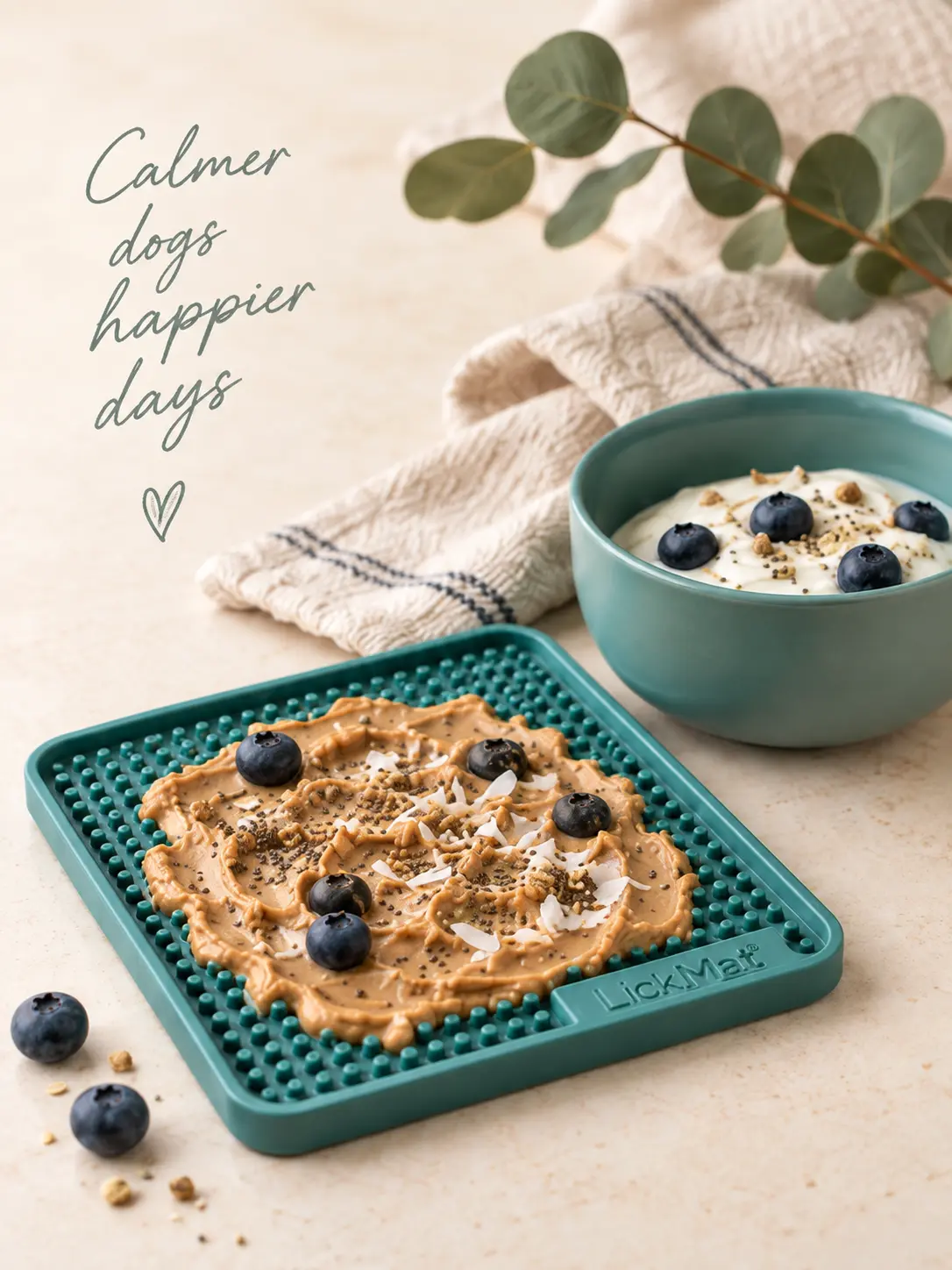 Calmer dogs, happier days: a teal lick mat spread with peanut butter and blueberries beside a bowl of yoghurt