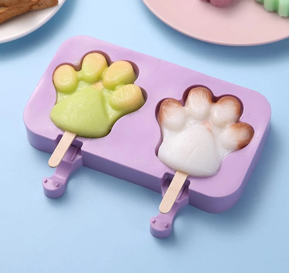 Purple silicone paw-shaped popsicle molds with wooden sticks